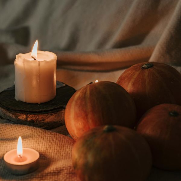 A burning candle, a cup of herbal tea, and a soft blanket creating a cozy atmosphere.