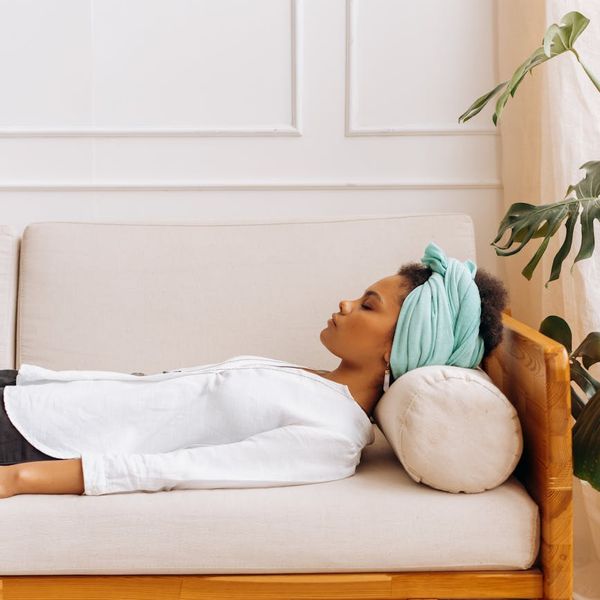 Woman in a calming yoga pose in a softly lit room.